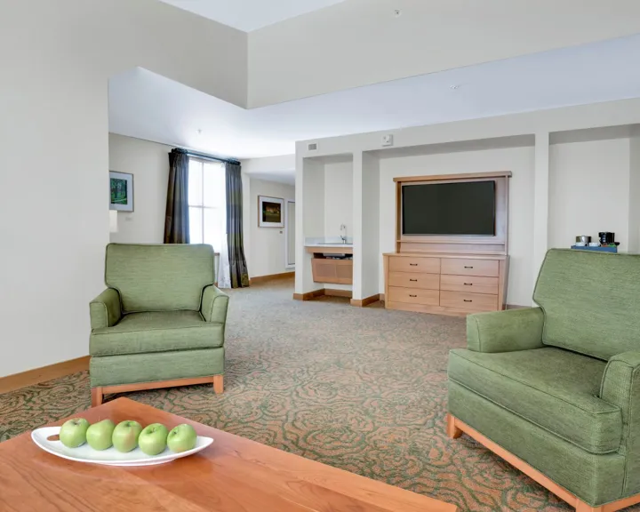 Double queen suite living space with chairs and a TV