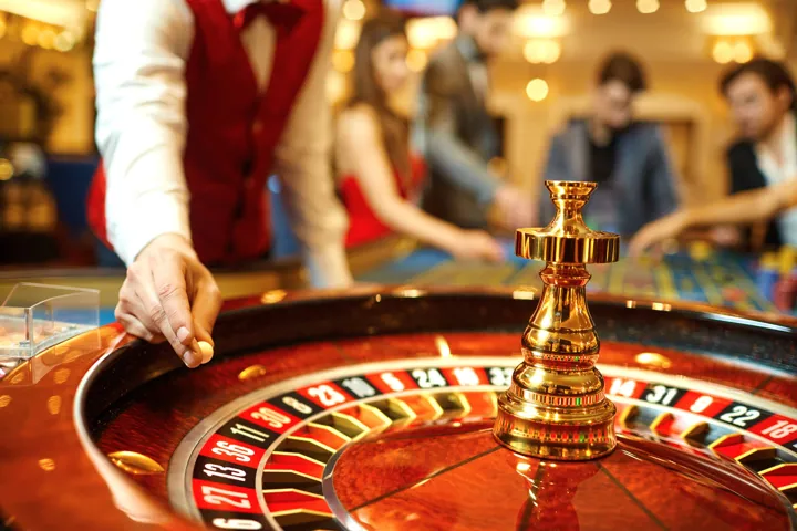 Dealer getting a roulette wheel ready at a casino